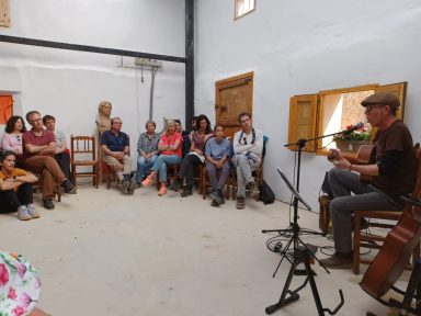 Concierto de Danilo Un grupo de personas escucha a un músico en un espacio interior.