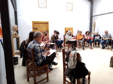 Encuentro de dibujo al natural Grupo de personas sentadas en sillas, participando en una actividad en un espacio compartido.
