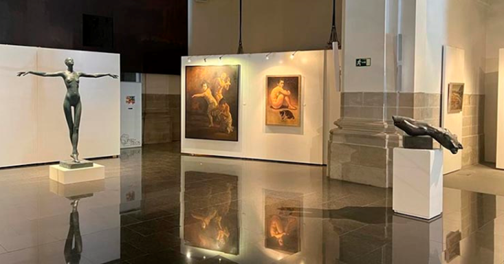 Esculturas y pinturas en una galería de arte con suelo brillante.