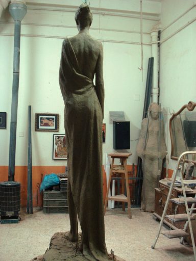 Escultura de una figura femenina de pie, en un estudio de arte.