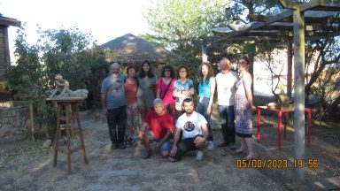 Grupo de personas posando al aire libre, rodeadas de árboles y un entorno rural.