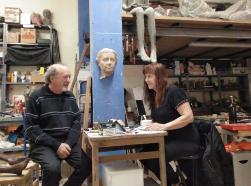 Un hombre y una mujer charlando de buen humor en un taller de escultura